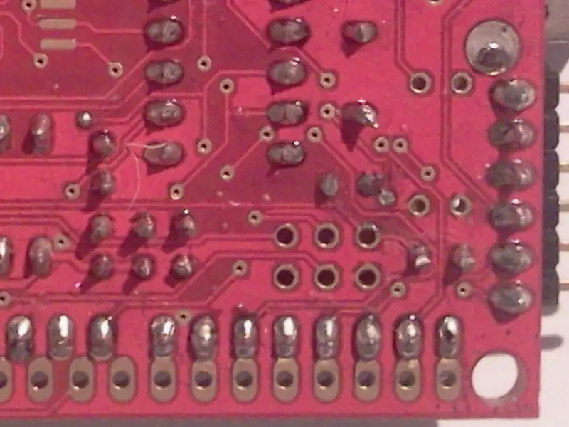 A close up photograph of soldering that has inadvertently bridged two pads causing the board to fail.