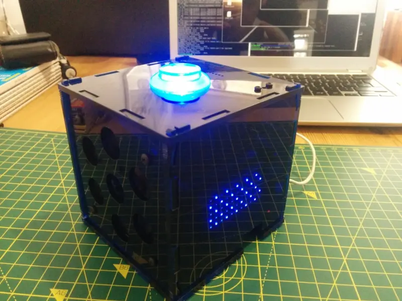 It works. The blue square perspex cube has a blue flashing LED button meaning that GoogleAIY is actively listening for commands and the blue ScrollPHAT LED display is getting ready to show the time.