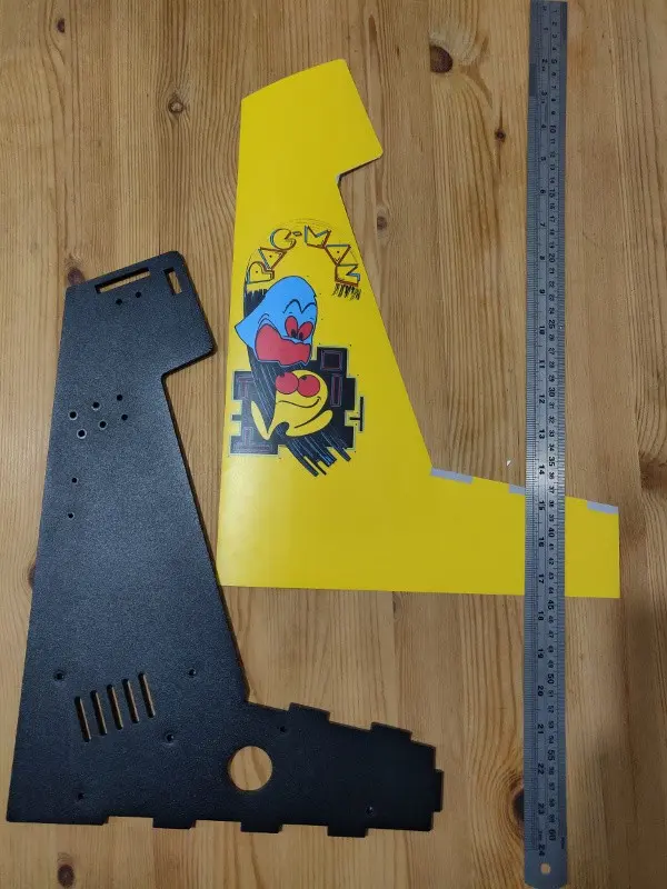 The Pac-Man logo on the vinyl for the side of the Picade cabinet. It has been roughly trimmed but needs a more precise trim to finish it. It is shown next to the MDF pice it is to cover.