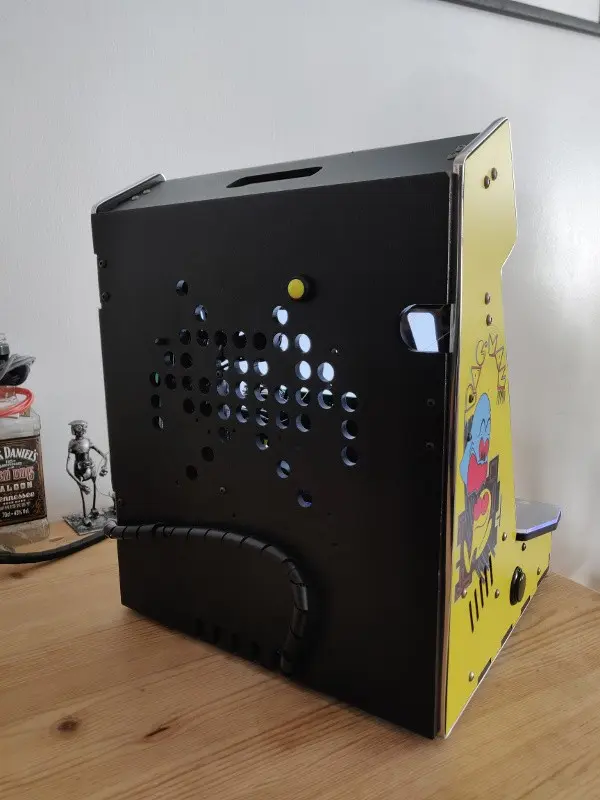 A rear view of the finished cabinet, ventilation holes in the shape of a Space Invader more visible now that the machine has booted .